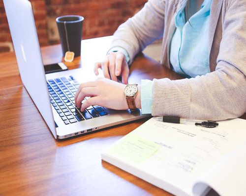 A professional typing an email on a laptop